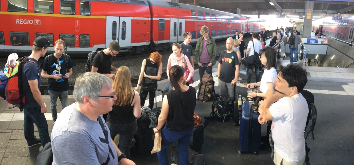 Photo of a bunch of IndieWeb community members standing around at a train station